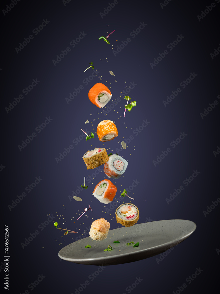 The stock image shows a hovering plate with seven pieces of sushi, sesami seeds, seeds and garnish falling in the direction of the plate